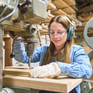 Junge Frau arbeitet in einer Schreinerei