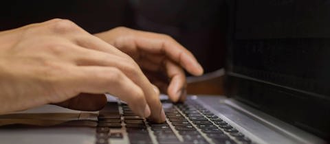 Hände auf Laptop-Tastatur, Nahaufnahme der Hände auf der Tastatur