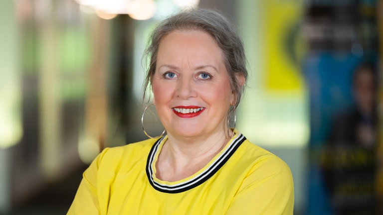 Moderatorin Barbara Scherrer aus dem SWR1 Team schaut direkt in die Kamera und trägt ein gelbes Oberteil - sie moderierte regelmäßig den Musik Klub Soul und den Musik Klub Goldies