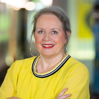 Moderatorin Barbara Scherrer aus dem SWR1 Team schaut direkt in die Kamera und trägt ein gelbes Oberteil - sie moderierte regelmäßig den Musik Klub Soul und den Musik Klub Goldies