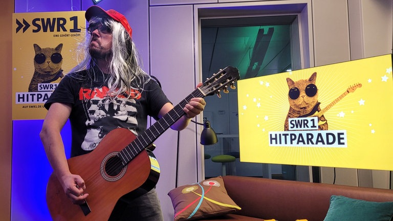 SWR1 Moderator Ingo Lege mit Perücke und Gitarre