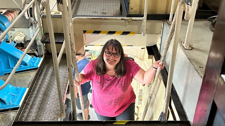 Der perfekte Tag mit SWR1 am Mannheimer Hafen: zu Besuch auf dem Museumsschiff, einem alten Schaufelraddampfer. Gewinnerin Verena steigt eine steile Stahltreppe zum Maschinenraum hoch.