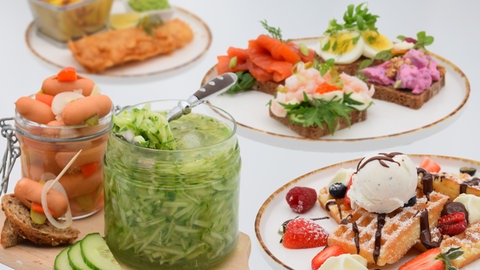 Vier verschiedene Snacks: Gurkensalat, Waffeln mit Eis, Smörrebröd und Fish and Chips