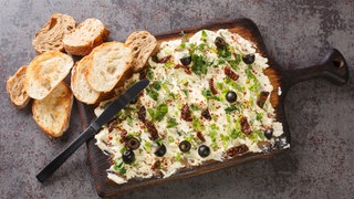 Butter Board mit Oliven, Frühlingszwiebeln und getrockneten Tomaten