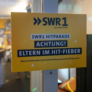 Schild mit der Aufschrift Eltern im Hit-Fieber