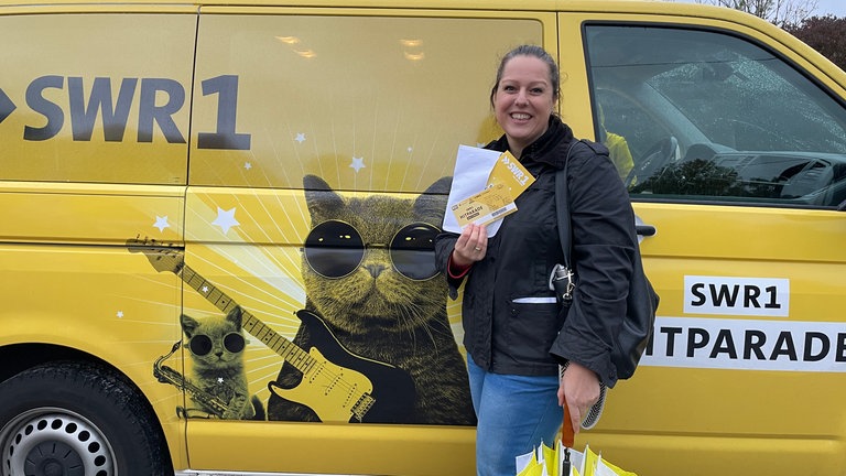 Frau hält Tickets in der Hand. In Weissach im Tal haben zwar nur 244 Menschen gesungen, trotzdem gab es Ticket für die SWR1 Hitparaden-Finalparty zu gewinnen. 