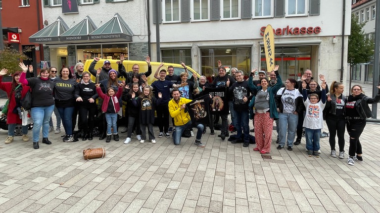 Gruppe steht mit Bandshirts vor dem SWR1 Auto auf dem Rathausplatz in Albstadt-Ebingen.