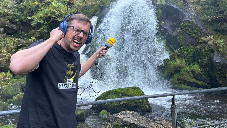 Moderator Ingo Lege steht vor den Triberger Wasserfällen.