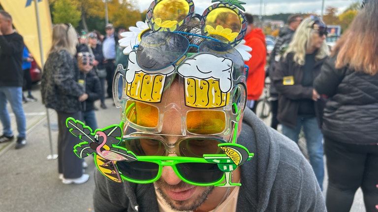 Mann hat mehr als sechs Sonnebrillen auf dem Kopf gestapelt. 