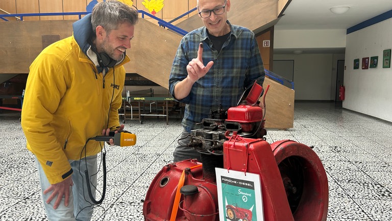 Schulleiter der Schefflenztalschule, Markus Hebestreit, ist zwar noch nicht passend gekleidet, aber schwarze Finger hat er schon vom Schrauben an seinem alten Porsche-Traktor. Dabei helfen ihm auch oft die Schülerinnen und Schüler seiner Schule in verschiedenen AGs.