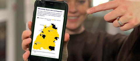 Cora Klausnitzer zeigt mit dem Finger auf die Statistik der SWR1 BW Hitparade 2025 auf ihrem Smartphone