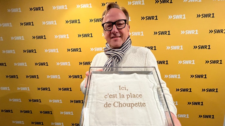 Oliver Krimmel, Meister-Sammler aus Stuttgart, mit dem Kissen von Choupette, der Katze von Karl Lagerfeld. Auf dem weißen Kissen steht in gold gestickt "Ici, c'est la place de Choupette".