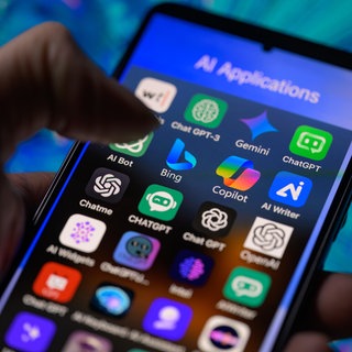 Eine Hand scrollt über einen Bildschirm, auf dem verschiedene KI-Apps zu sehen sind. Eine Studie der Europäischen Rundfunkunion zeigt alarmierende Fehlerquoten bei populären KI-Chatbots. Die Systeme erfinden regelmäßig Informationen.