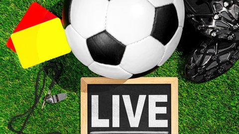Symbolbild zur FIFA Fußball-WM 2026: Fußball, Schiedsrichterkarten und der Schriftzug "live" stehen symbolisch für Liveübertragungen.