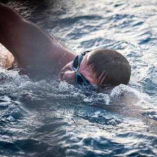 Extremschwimmer André Wiersig taucht aus den Wellen zum Atmen auf.