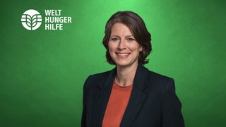Bettina Iseli, Vorstand Welthungerhilfe, lächelt vor einer grünen Wand in die Kamera.