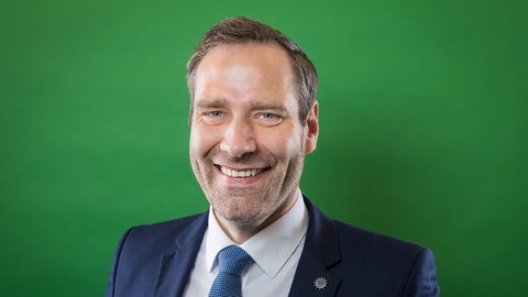 Jochen Kopelke, Bundesvorsitzender der Polizei-Gewerkschaft, lacht fröhlich in die Kamera.