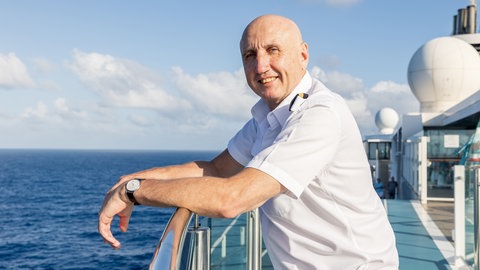 Dr. Reinhard Friedl steht auf einem Kreuzfahrtschiff | SWR1 Leute | Schiffsarzt Dr. Reinhard Friedl: Von Liebeskummer bis Lebensgefahr