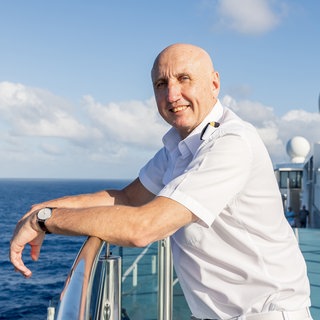 Dr. Reinhard Friedl steht auf einem Kreuzfahrtschiff | SWR1 Leute | Schiffsarzt Dr. Reinhard Friedl: Von Liebeskummer bis Lebensgefahr