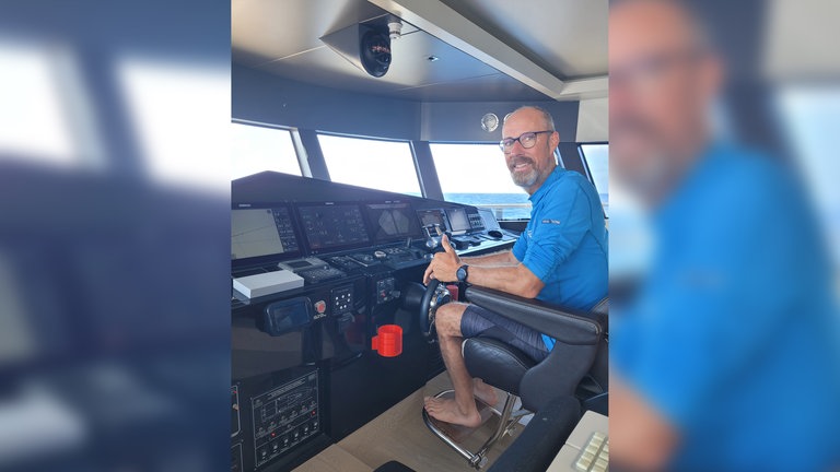 Extremsportler Martin Stengele sitzt auf der Brücke seines Ruderbootes.