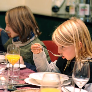 Sind Etikette und gutes Benehmen nicht mehr zeitgemäß? Knigge Expertin Carolin Lüdemann verrät in SWR1 Leute, welche Benimmregeln auch heute noch besonders wichtig sind. Das Bild zeigt junge Teilnehmer am Tischmanieren-Kurs - ein Mädchen führt einen Suppenlöffel gekonnt an den Mund.