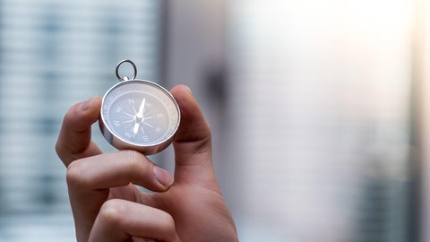 Ein Kompass wird in einer Hand gehalten. Ein Symbolbild für den Kompass 4 Leistungstest, den Grundschülerinnen und Schüler erbringen sollen, um auf das Gymnasium gehen zu dürfen.