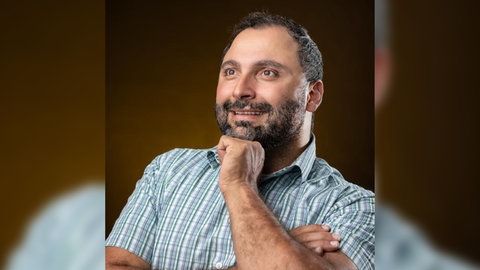 Mohamed Zakzak, Inklusionsbeauftragter der Stadt Pforzheim, blickt mit der Faust unterm Kinn in die Ferne.