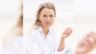 Nova Meierhenrich, Schauspielerin und Moderatorin, blickt etwas ernst in die Kamera.