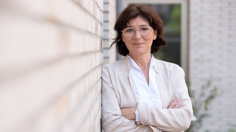 Ökotrophologin und Studiengangsleiterin Food Management an der DHBW Heilbronn lehnt an einer Wand und verschränkt die Arme. Sie verrät in SWR1 Leute, wie personalisierte Ernährung funktioniert und wie sie sogar beim Abnehmen helfen kann.