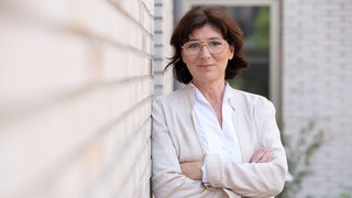 Ökotrophologin und Studiengangsleiterin Food Management an der DHBW Heilbronn lehnt an einer Wand und verschränkt die Arme. Sie verrät in SWR1 Leute, wie personalisierte Ernährung funktioniert und wie sie sogar beim Abnehmen helfen kann.