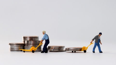 Eine Miniatur-Puppe ziehen einen Haufen Geldmünzen hinter sich her. David Kamer ist Schuldnerberater und gibt in SWR1 Leute Tipps, wie Überschuldung vermieden werden kann. Außerdem erklärt er, wie Menschen einen Weg aus den Schulden finden.