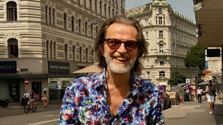 Reisejournalist und Autor Helge Timmerberg lacht in die Kamera.