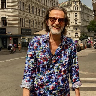 Reisejournalist und Autor Helge Timmerberg lacht in die Kamera.