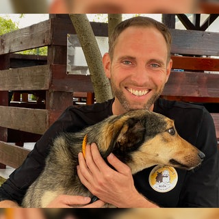 Matthias Schmidt | Verein "Tierhilfe Hoffnung" und Leiter des weltgrößten Tierheims Smeura in PitestiRumänien, mit 6.000 Hunden und 450 Katzen. Er hält einen der Heimhunde auf dem Arm und stahlt in die Kamera.