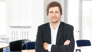 Moritz Schularick, Chef des Instituts für Weltwirtschaft, schaut mit überschränkten Armen in die Kamera. In SWR1 Leute nutzen wir die Gelegenheit, um mit Prof. Moritz Schularick zu erörtern, wie es denn aktuell wirklich um den Wirtschaftsstandort Deutschland steht