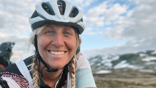 Abenteurerin Jasmin Böhm trägt einen Helm und lacht in die Kamera.