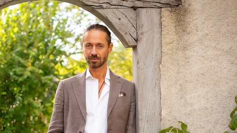 Philosoph Ben Rakidžija steht in einem Park. Tempo aus dem Alltag nehmen, weniger Handy-Abhängigkeit, mehr Pausen – und endlich wieder Mittagsschlaf! Das fordert der Philosoph, Yogalehrer und Zenmeister Ben Rakidžija in SWR1 Leute.