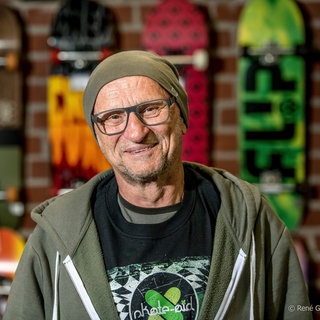 Titus Dittmann lächelt in die Kamera. Das Skateboard hat das Leben von Titus Dittmann komplett verändert: Der ehemalige Lehrer wurde zum Wegbereiter eines neues Sports. Mit seiner Organisation "skate-aid" baut er mittlerweile weltweit Skateparks für Kinder. In SWR1 Leute erzählt er, wie aus dem vermeintlich kurzfristigen Trend eine Bewegung wurde.