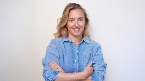 Journalistin und Podcasterin Verena Kleinmann steht mit überschränkten Armen da und lächelt in die Kamera. 70% der jungen Frauen in Deutschland haben den Wunsch nach Kindern. Journalistin Verena Kleinmann hat sich bewusst dagegen entschieden und wird dafür teils heftig kritisiert. Sie hat das zum Thema gemacht im ARD-Podcast "(K)ein Kinderwunsch" und in ihrem Buch "Alle kriegen Kinder, ich zweifle" und erzählt davon in SWR1 Leute.