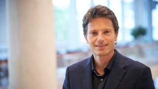 Enzo Weber, Wirtschaftswissenschaftler, blickt in die Kamera. Der Wirtschaftswissenschaftler Enzo Weber vom Institut für Arbeitsmarkt- und Berufsforschung hat einen genauen Blick auf die Wirtschaftslage Deutschlands. In SWR1 Leute beantwortet er die Frage, ob und wie sich die Konjunktur in Deutschland wieder erholen und verbessern kann.