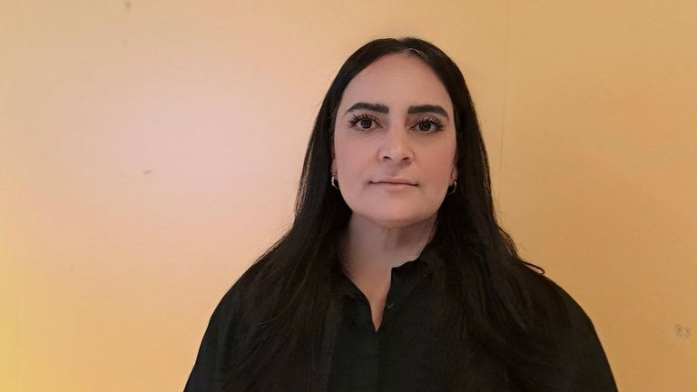 Gamze Kubaşık, politische Rednerin, blickt in die Kamera.