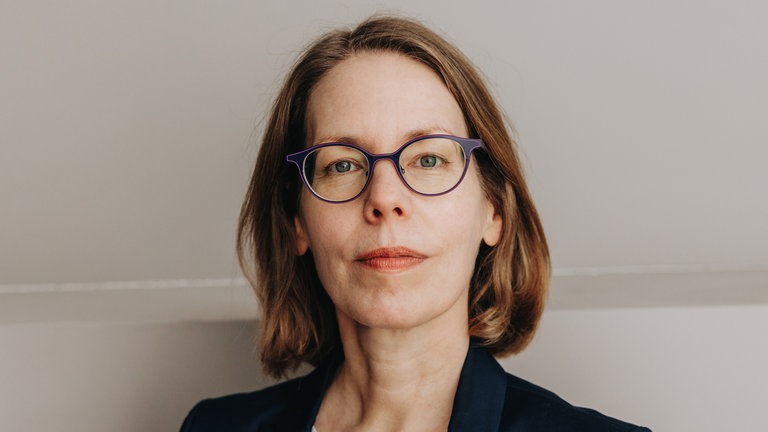 Anne Brorhilker, ehemalige Staatsanwältin, blickt in die Kamera. Sie spricht über den Kampf gegen Wirtschaftskriminalität.