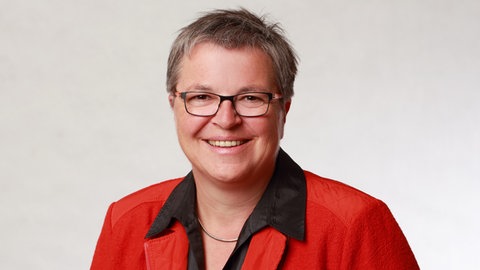 Brigitte Schäfer, Schulleiterin für Familienpflege, lächelt strahlend in die Kamera.  Sie ist die Leiterin der Berufsfachschule für Familienpflege Korntal. Dort werden Frauen und Männer zu Pflegefachkräften oder Aushilfs-Müttern und -Vätern ausgebildet. In SWR1 Leute erzählt sie, wie wichtig und vielschichtig die Arbeit der Familienpflegekräfte ist, um den Lebensalltag aufrechtzuhalten in Familien, die kurzzeitig ohne Hilfe nicht mehr auskommen.