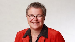 Brigitte Schäfer, Schulleiterin für Familienpflege, lächelt strahlend in die Kamera.  Sie ist die Leiterin der Berufsfachschule für Familienpflege Korntal. Dort werden Frauen und Männer zu Pflegefachkräften oder Aushilfs-Müttern und -Vätern ausgebildet. In SWR1 Leute erzählt sie, wie wichtig und vielschichtig die Arbeit der Familienpflegekräfte ist, um den Lebensalltag aufrechtzuhalten in Familien, die kurzzeitig ohne Hilfe nicht mehr auskommen.