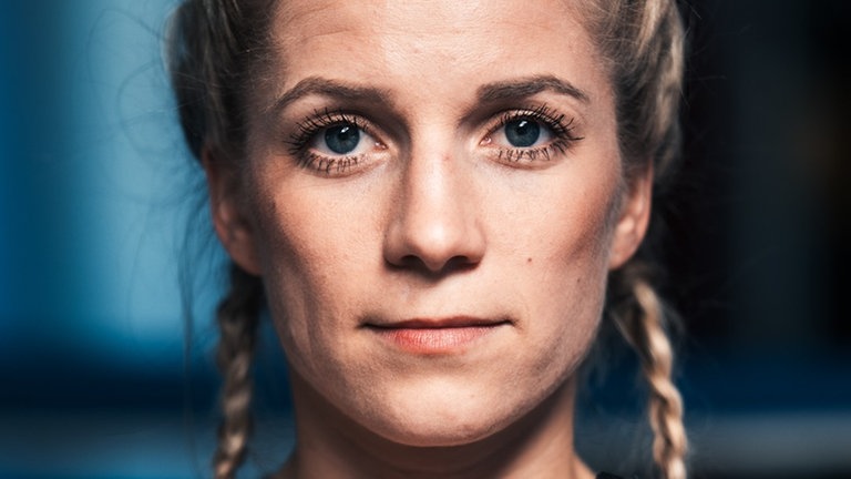 Boxerin Tina Rupprecht hält ihre geflochtenen Zöpfe.
