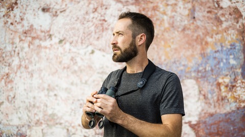 Ornithologe Leander Khil mit Fernrohr. Er gibt Naturfotoworkshops und leitet Vogelführungen. Er ist zu Gast in SWR1 Leute
