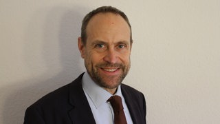 Ulrich Arndt, Jurist und Leiter Servicestelle Bürgerbeteiligung BW, lacht in die Kamera.