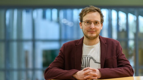 Gesundheitsökonom Prof. Simon Reif schaut in die Kamera. In SWR1 Leute spricht er über das deutsche Gesundheitssystem, steigende Krankenkassenbeiträge und die Finanznot der Krankenkassen.