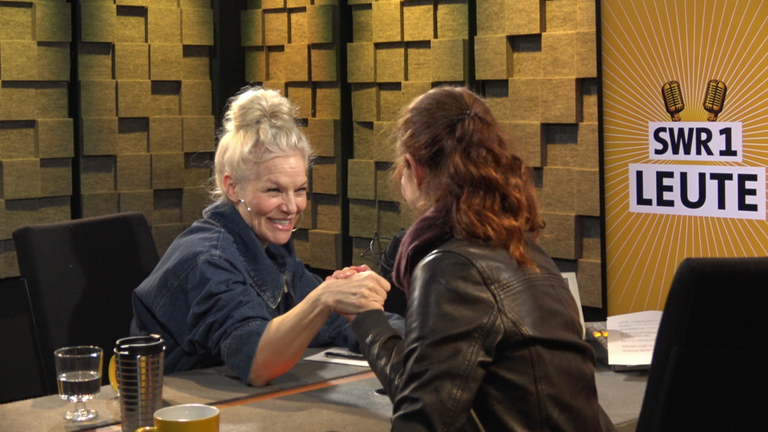 Musikerin Ina Müller und SWR1 Moderatorin Nicole Köster messen sich im Armdrücken. Ina Müller ist Moderatorin, Sängerin und Entertainerin. Sie wird auch das "Schweizer Taschenmesser des NDR" genannt. Mit ihrem Album "6.0" stieg sie auf Platz 1 der Charts ein.