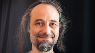 Prof. Morten Moshagen schaut direkt in die Kamera.  Hassreden, Diebstahl, Mobbing: Woher kommen Boshaftigkeit oder gar das echte Böse im Menschen? Der Ulmer Psychologe Morten Moshagen forscht daran und fand den "Dark Factor". Was dahinter steckt, erklärt er in SWR1 Leute.